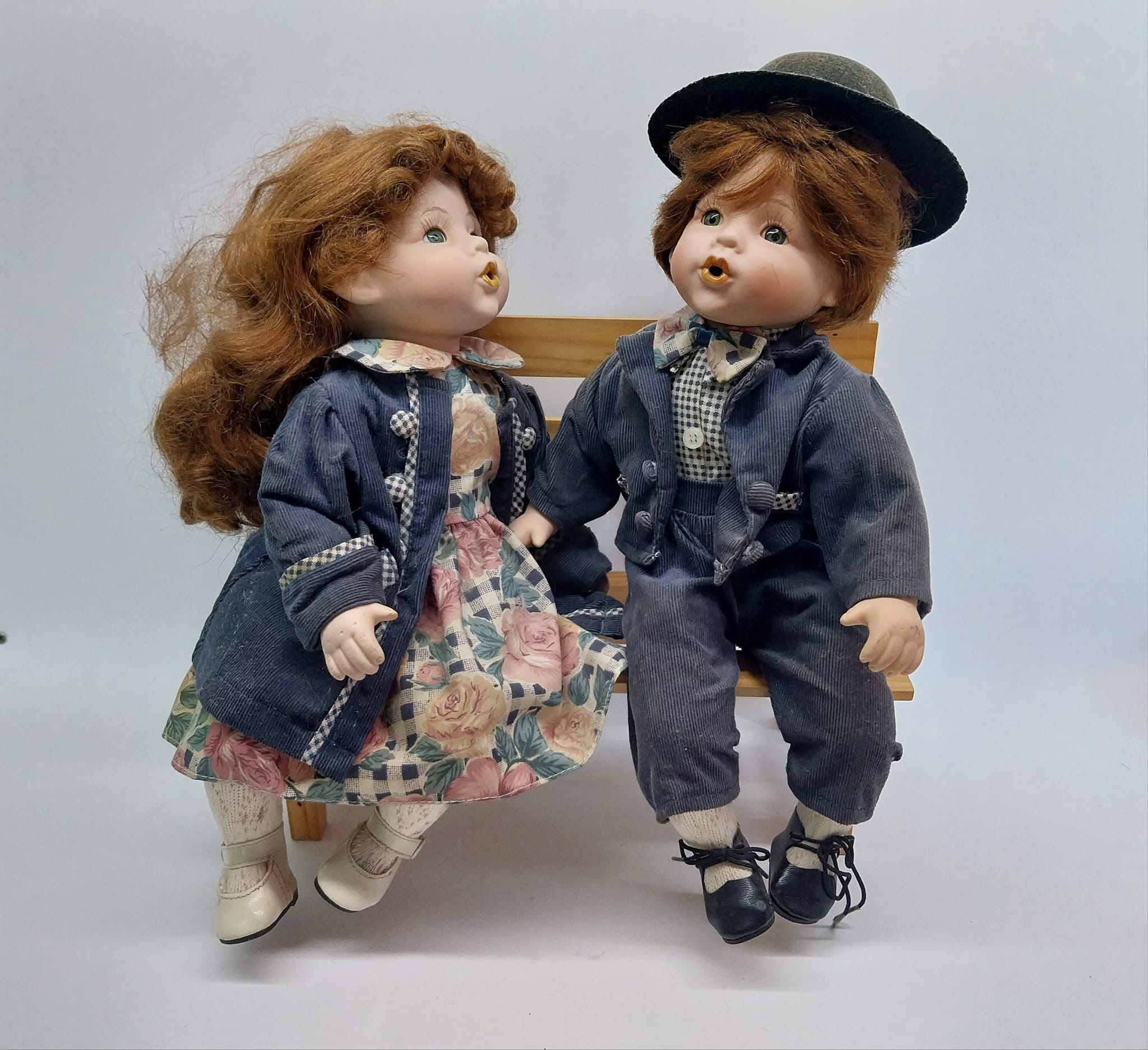 Vintage porcelain dolls - boy and girl on a wooden bench, from the 70s