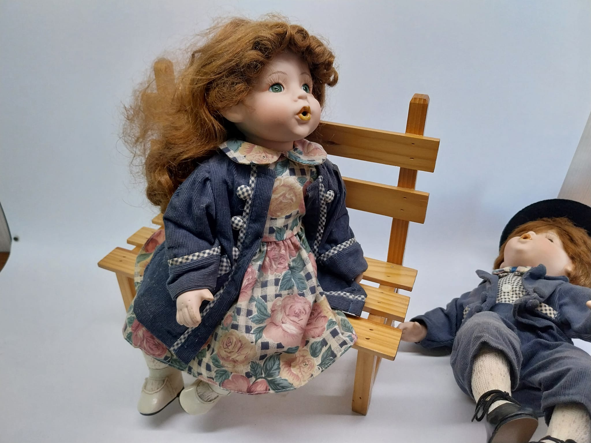 Vintage porcelain dolls - boy and girl on a wooden bench, from the 70s