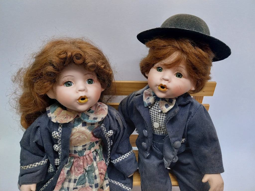 Vintage porcelain dolls - boy and girl on a wooden bench, from the 70s