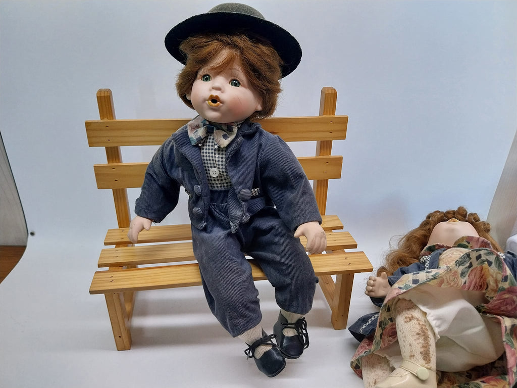 Vintage porcelain dolls - boy and girl on a wooden bench, from the 70s