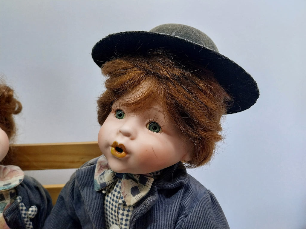Vintage porcelain dolls - boy and girl on a wooden bench, from the 70s