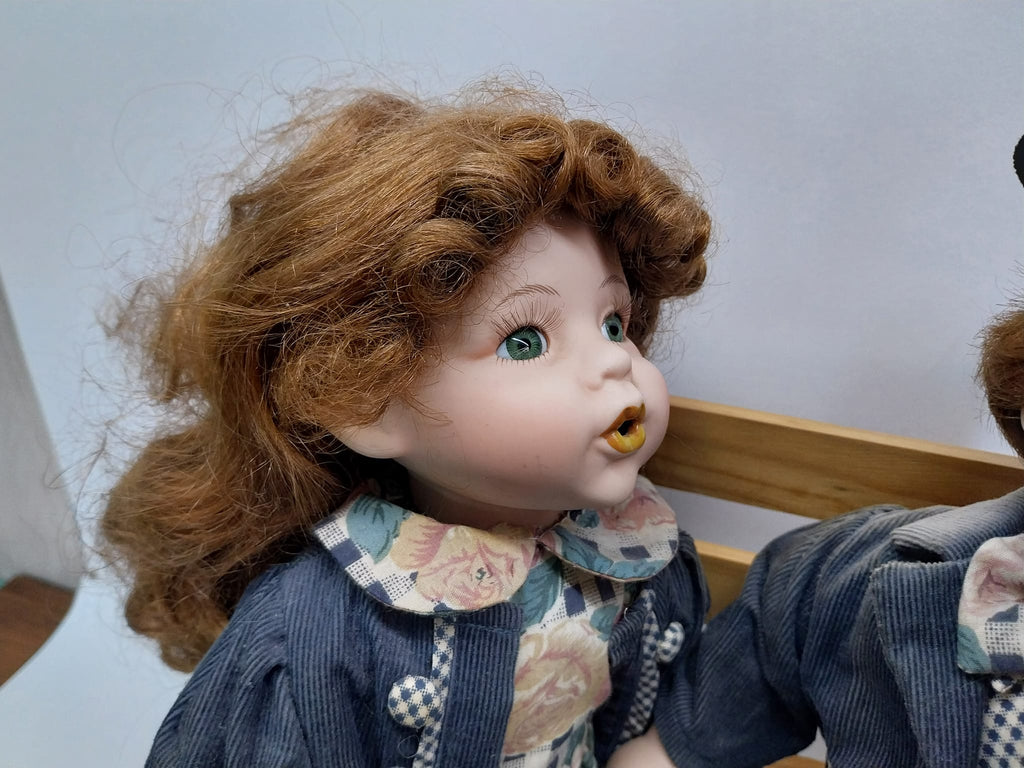 Vintage porcelain dolls - boy and girl on a wooden bench, from the 70s