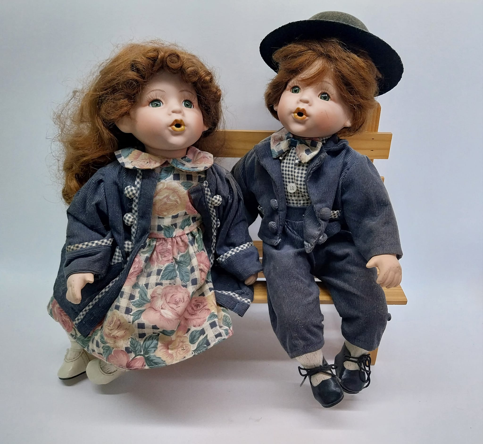 Vintage porcelain dolls - boy and girl on a wooden bench, from the 70s