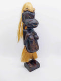Vintage dark hardwood tribal carved figure with raffia hair and skirt, Melanesian style