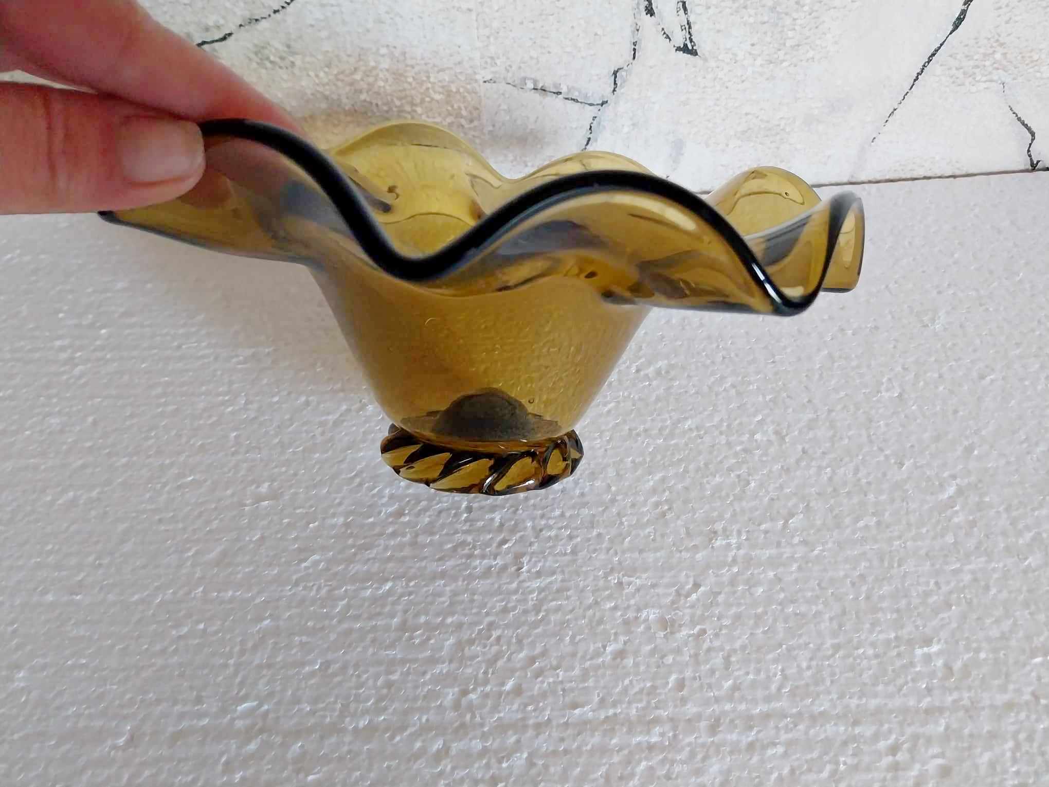 Close-up of ruffled rim and twisted base of vintage Bulgarian amber glass bowl