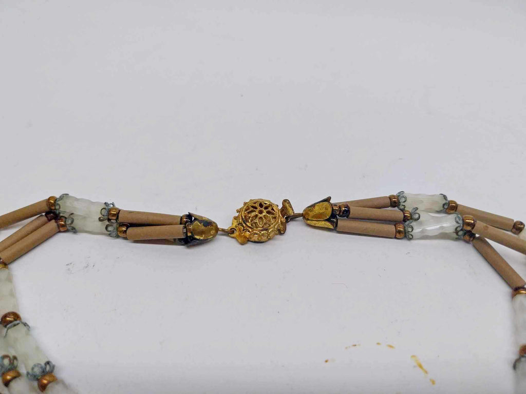 Close-up of gold floral medallion clasp on vintage beaded necklace
