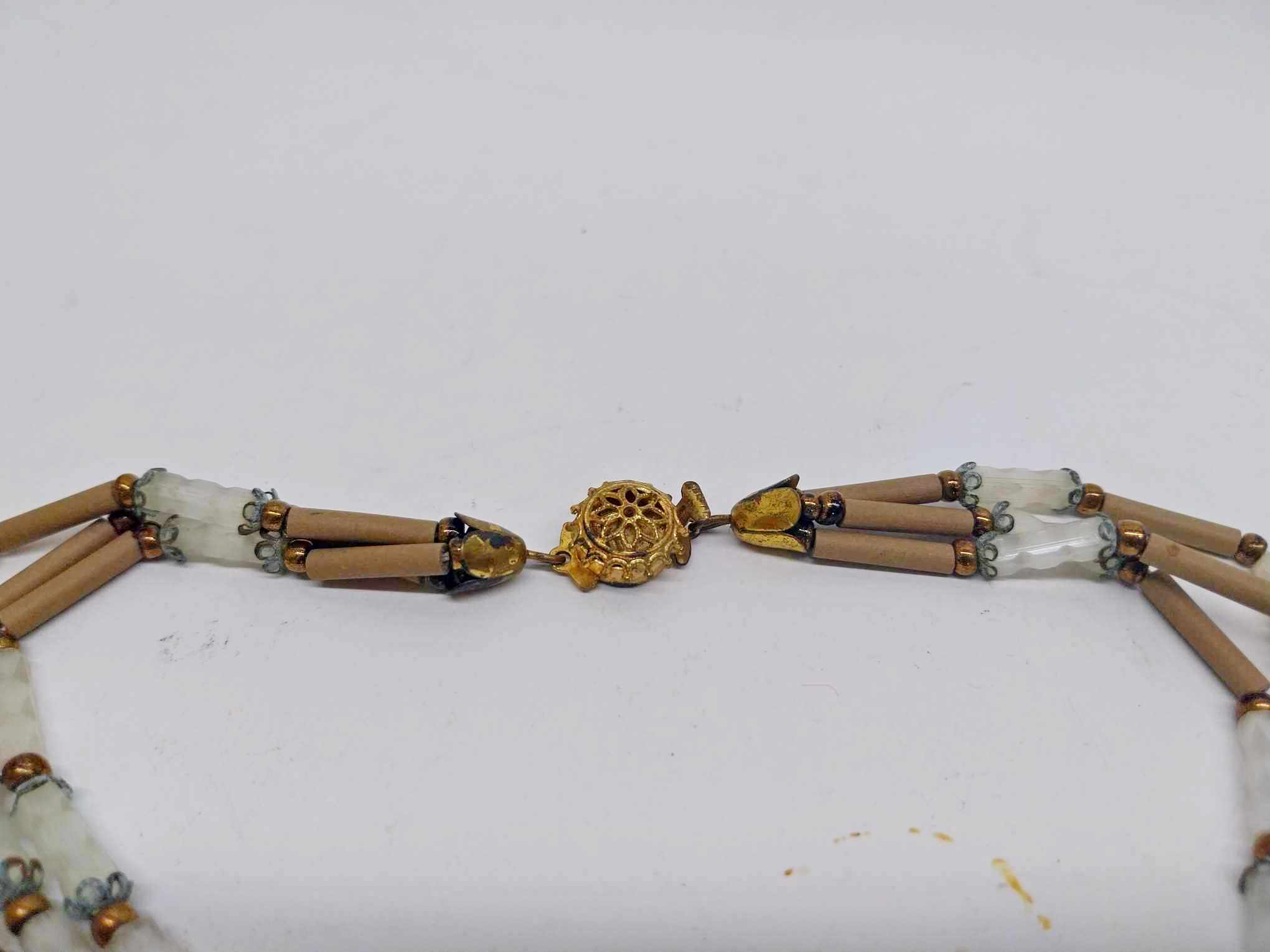 Close-up of gold floral medallion clasp on vintage beaded necklace