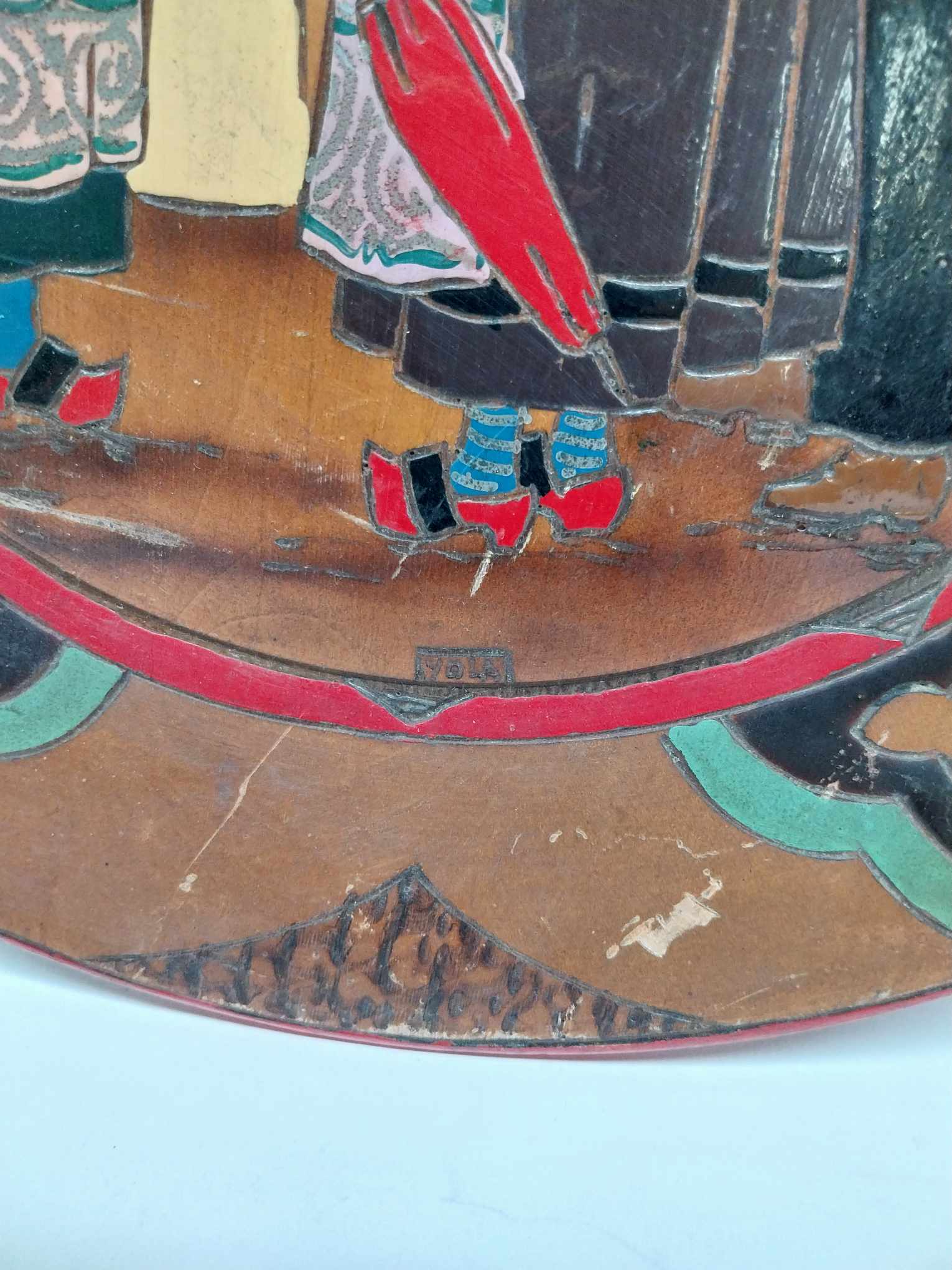 Close-up detail of cloisonné enamel and wear on vintage French decorative plate