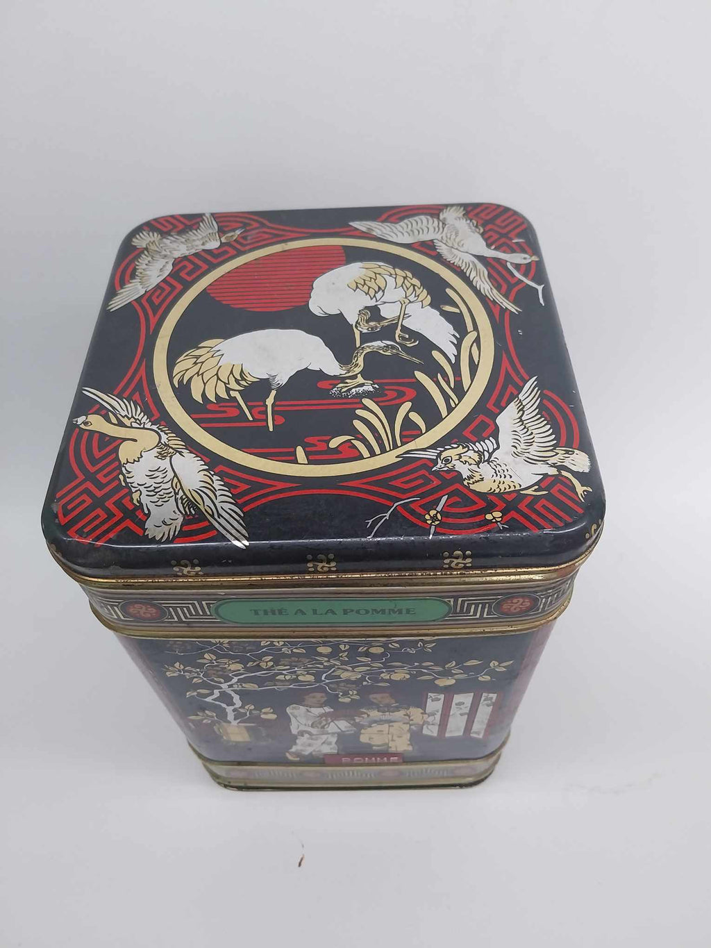 Vintage apple tea tin top view with crane design