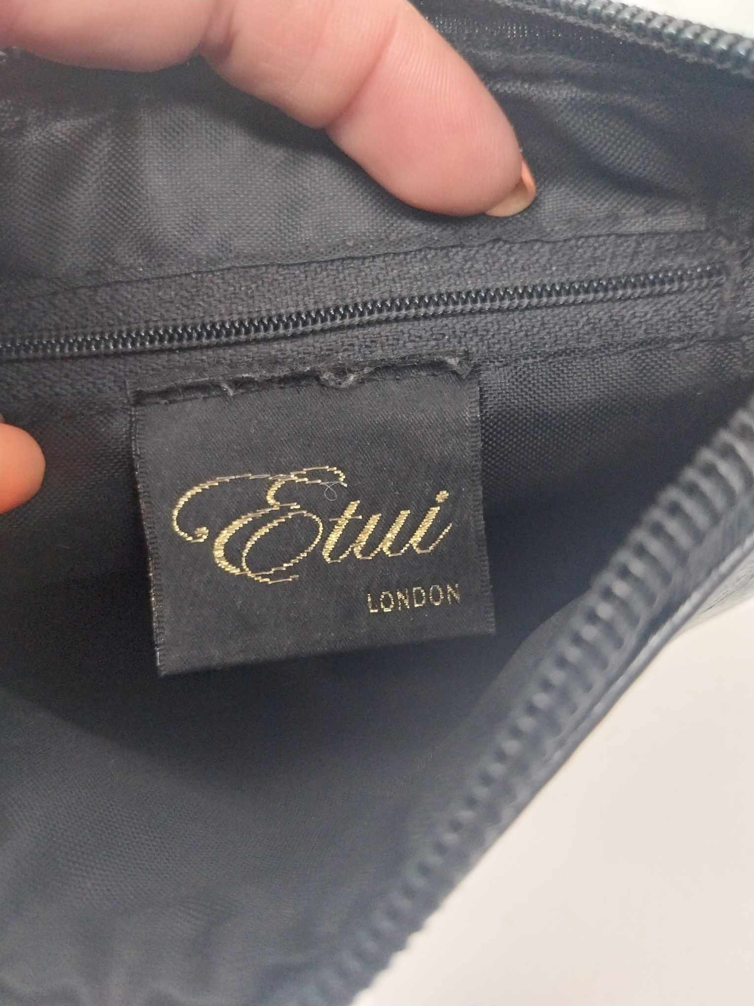 Interior of Etui London bag showing embroidered gold label and zip pocket lining