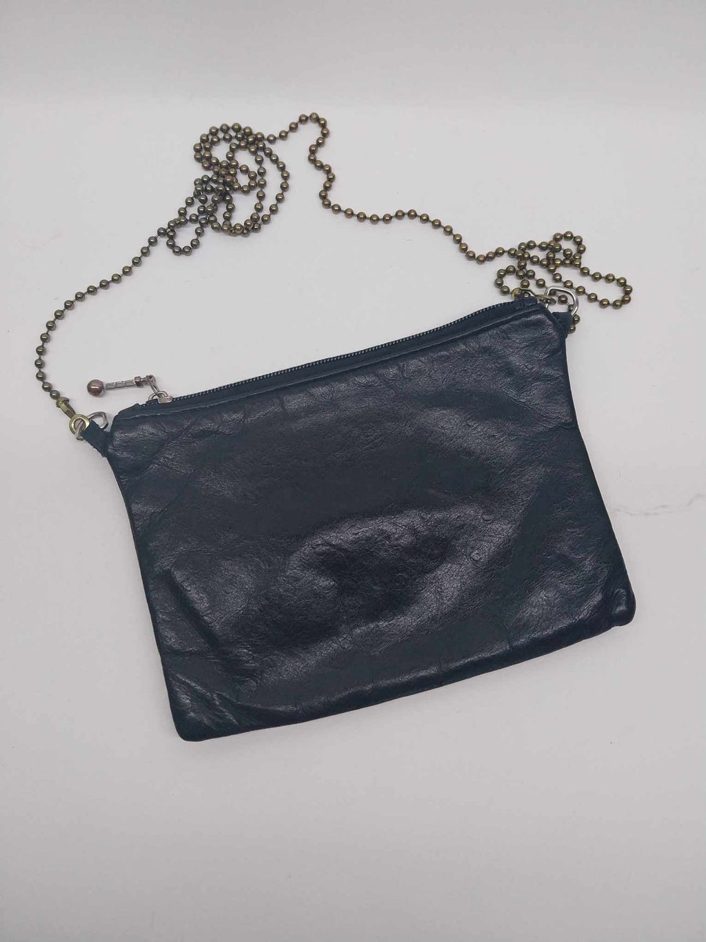 Vintage Etui London black leather clutch bag with antique bronze ball chain strap, flat lay on white background