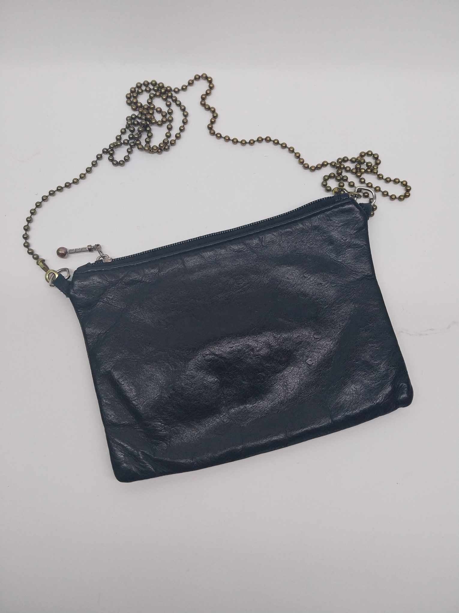 Vintage Etui London black leather clutch bag with antique bronze ball chain strap, flat lay on white background