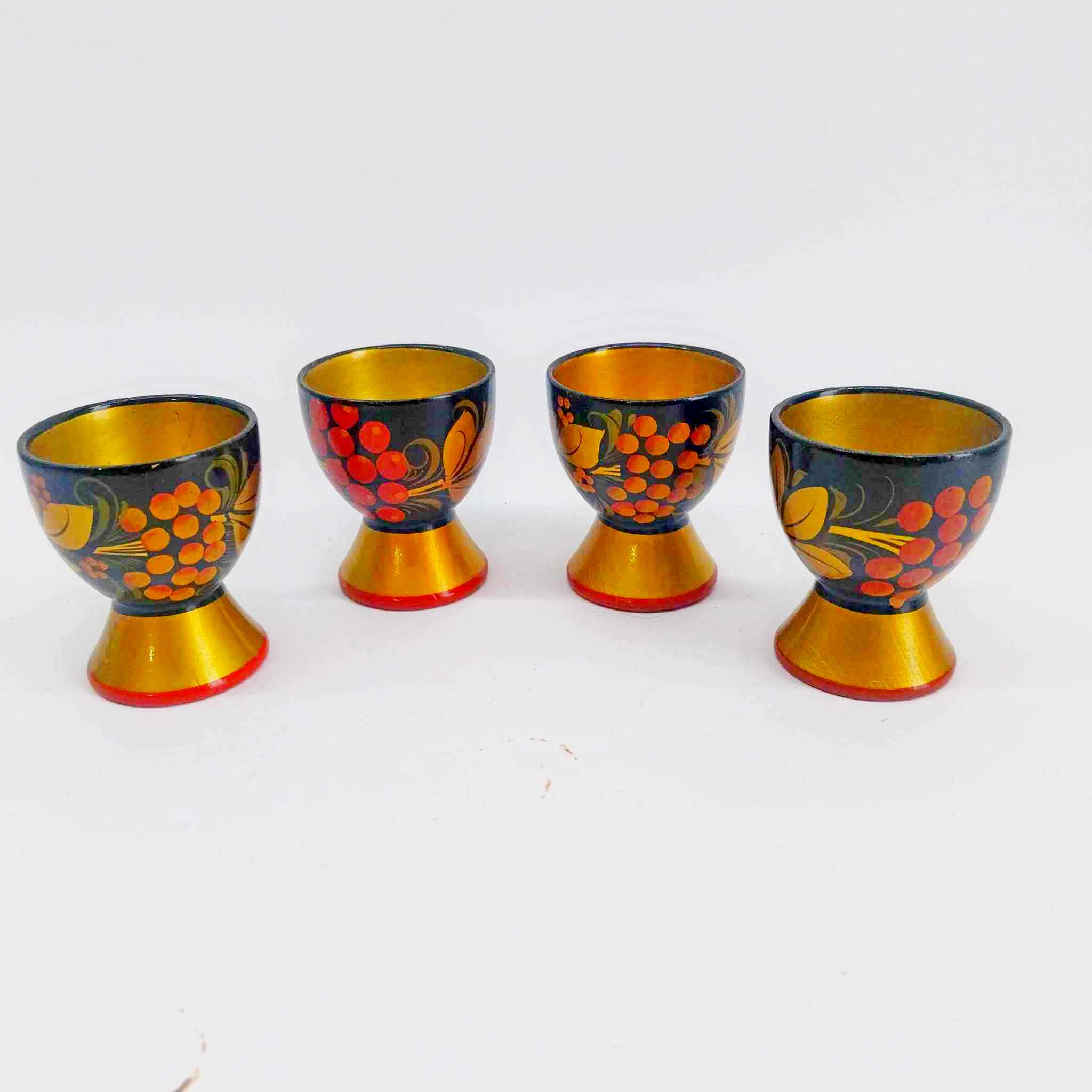 Set of 4 vintage Russian Khokhloma hand-painted wooden egg cups with red berry motifs and gold interior