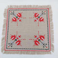 Vintage hand-embroidered linen doily with red folk cross-stitch motifs and fringed border, 33cm