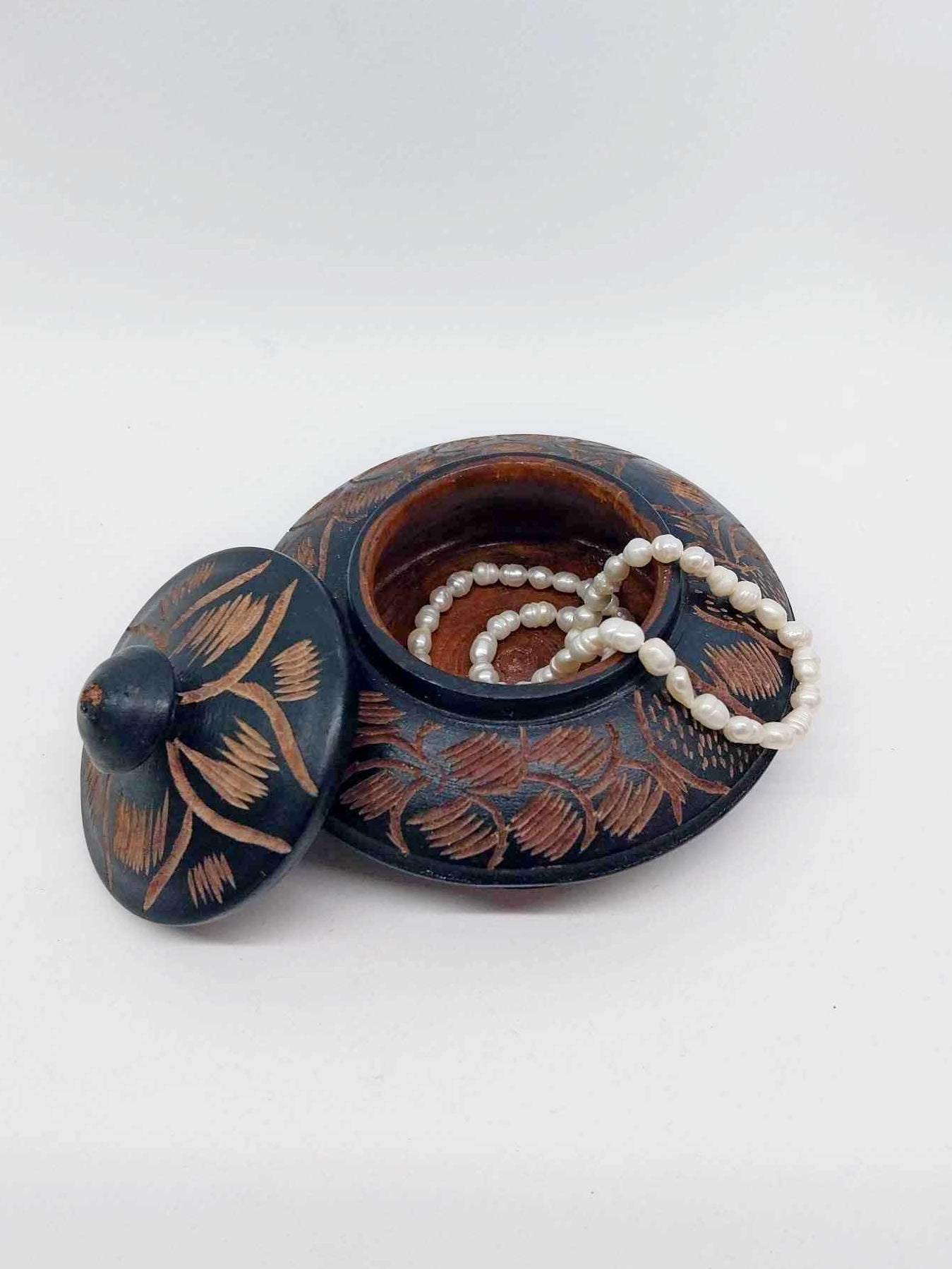 Vintage hand-carved wooden jewellery box open with lid beside it, showing floral carved pattern