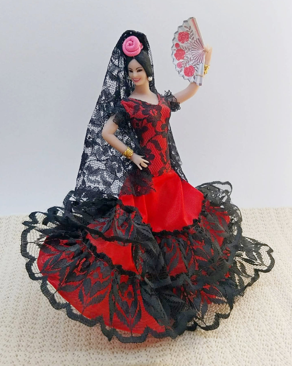 Vintage flamenco dancer doll in red and black lace dress holding a fan