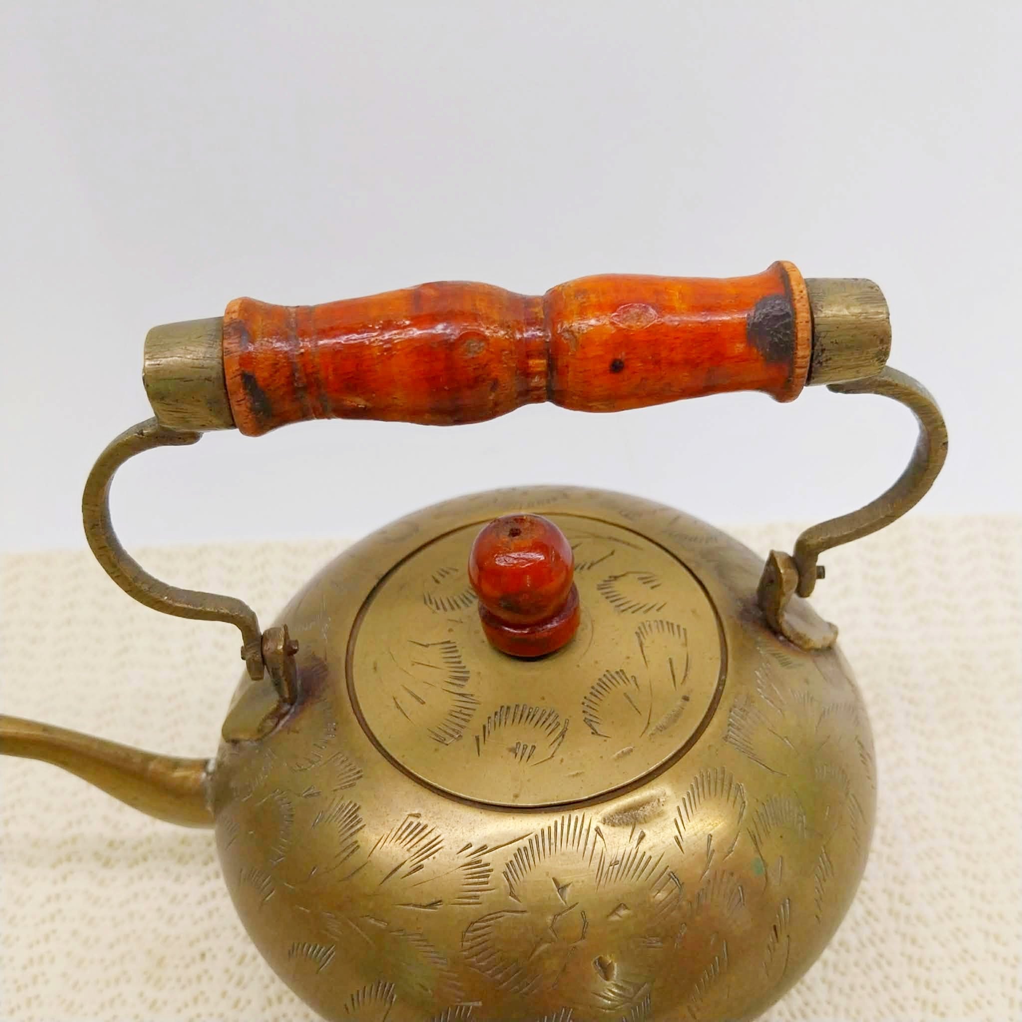 Close-up of vintage brass teapot lid and wooden handle