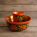 Vintage Khokhloma hand-painted wooden bowl and cup set on rustic wooden surface