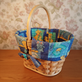 Vintage wicker basket with blue novelty fabric lining on warm wooden surface