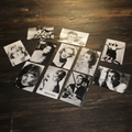 Collection of vintage 1960s European film stars black and white photo cards on rustic wooden surface