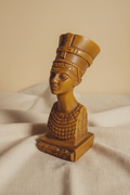 Vintage polyresin bust of Queen Nefertiti in warm honey-brown tone on cream linen background